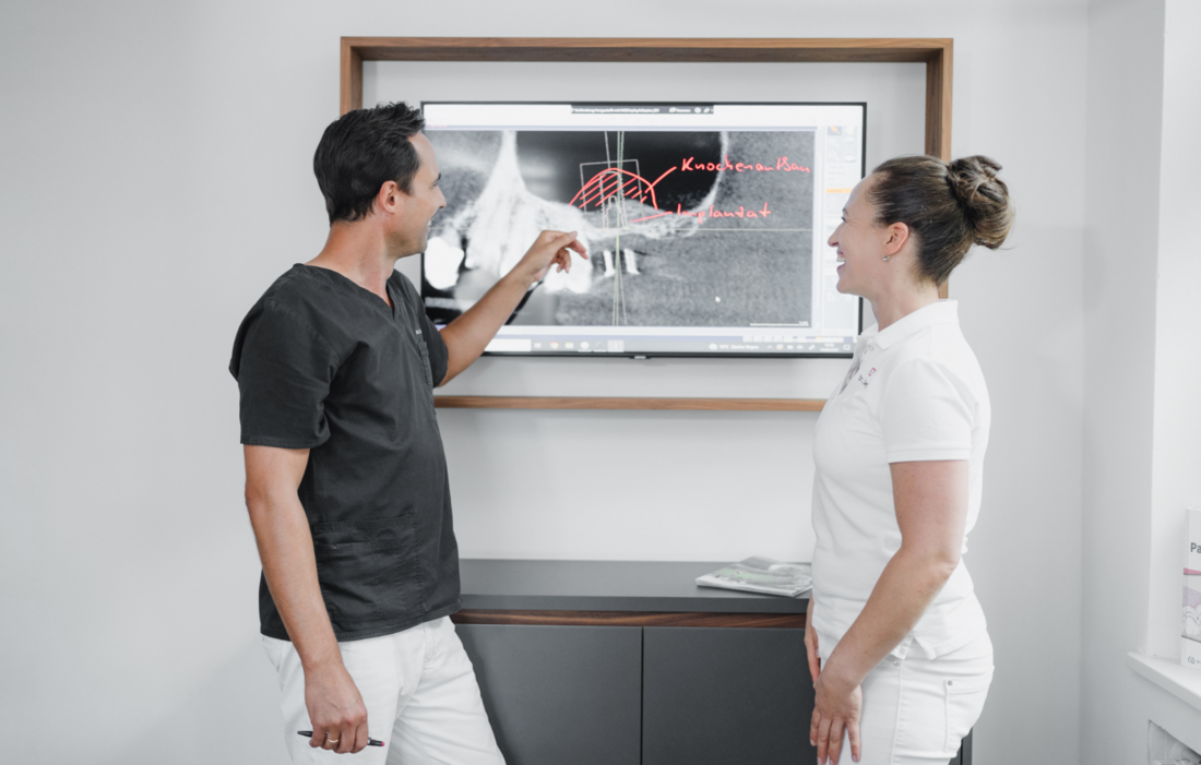 Dr. Weiniert und Dr. Georg schauen sich ein Röntgenbild am Bildschirm an
